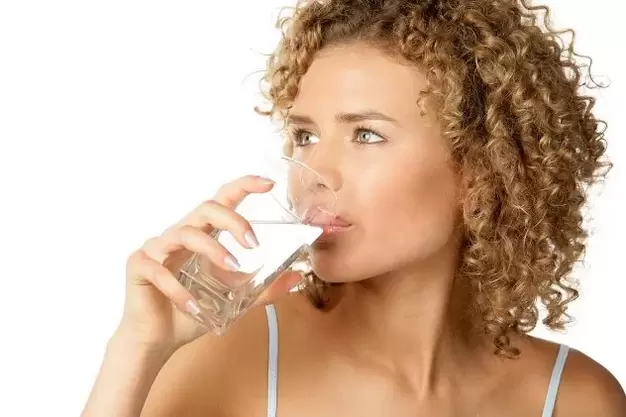 The girl follows a diet for lazy people, she drinks a glass of water before eating